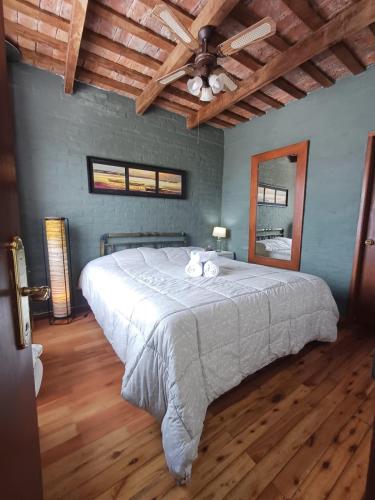 a bedroom with a large bed and a wooden floor at Posada San Gabriel in Colonia del Sacramento