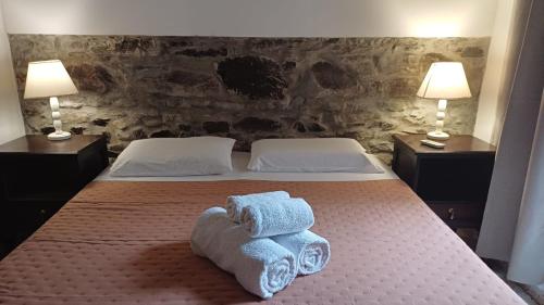 a bedroom with a bed with towels on it at Posada San Gabriel in Colonia del Sacramento