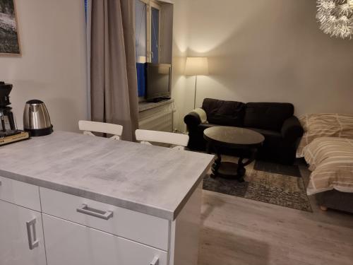 a kitchen and living room with a table and a couch at Studio Porin Oksi, home away home in Pori city center, free parking in Pori