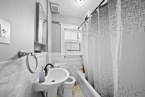 a white bathroom with a sink and a toilet at Stylish Luxury 3bd home in Down Town Royal Oak in Royal Oak