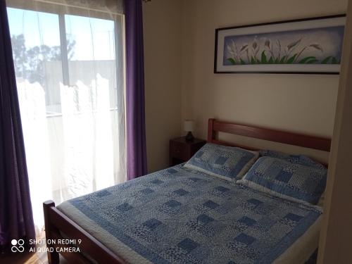Schlafzimmer mit einem Bett, einem Fenster und einer Decke in der Unterkunft Cabanas Piedras Preciosas in El Quisco