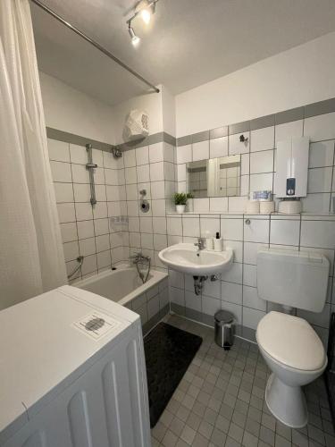 a bathroom with a toilet and a sink and a tub at Premium Apartment 3 in Dillingen an der Saar
