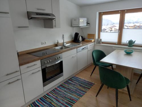 a kitchen with white cabinets and a table and a sink at Lovely Rita, Studio Kaprun in Kaprun
