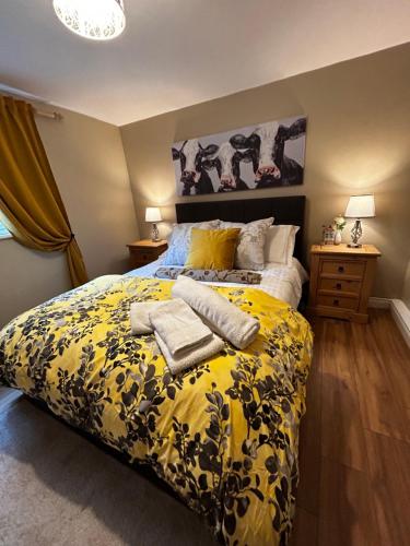 sypialnia z żółtym łóżkiem i ręcznikami w obiekcie Lemonade Cottages and Retreat w mieście Kilrush