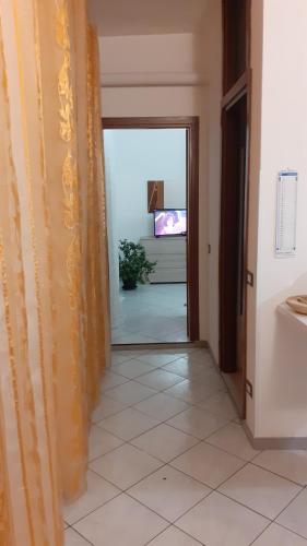 pasillo con puerta abierta a una habitación con TV en Casa Vacanza Pineta, en Oltrona di San Mamette