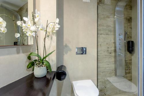 ein Badezimmer mit einer Vase aus Blumen auf der Theke in der Unterkunft Eurohotel Katrin Suites in Stalida