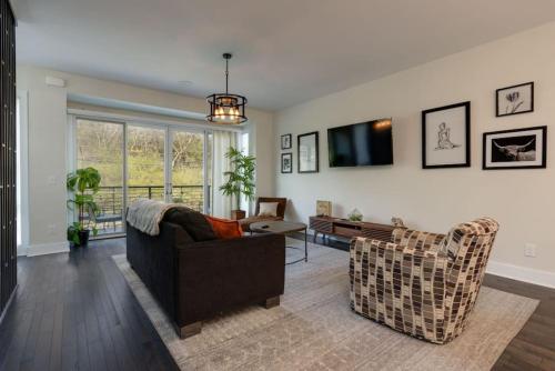 a living room with a couch and a table at Modern Townhome, Large Game Room with Ping Pong, 10min to Downtown! Sleeps 10! in Nashville