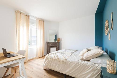une chambre avec un lit et un bureau avec un ordinateur portable dans l'établissement La Clef - appartement proche centre et gare, à Saint-Brieuc