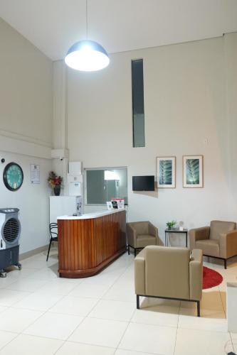 a waiting room with chairs and a counter in a building at Hotel Neblina in Araguaína