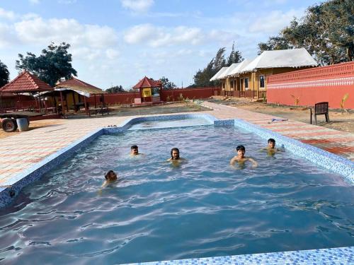 um grupo de pessoas a nadar numa piscina em Santkrupa Villa Resort em Nakhtrana