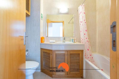 a bathroom with a sink and a toilet and a mirror at #199 Flamingo 1108 by Home Holidays in Portimão