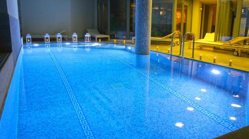 a large blue swimming pool in a hotel at Aegli Arachova in Arachova