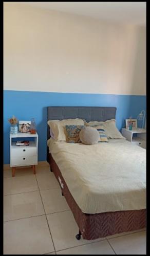 Schlafzimmer mit einem Bett mit blauer Wand in der Unterkunft Casa temporada 