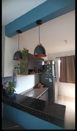 a kitchen with two pendant lights and a refrigerator at Casa temporada 