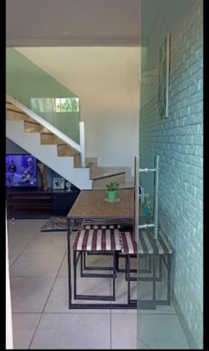 uma mesa e banco num quarto com escadas em Casa temporada 