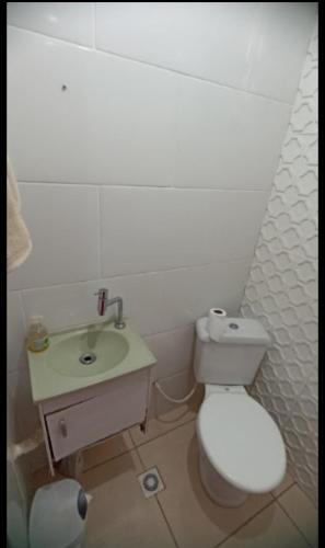 a bathroom with a white toilet and a sink at Casa temporada 