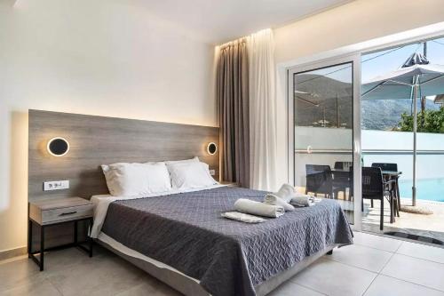 a bedroom with a large bed and a balcony at BLUE STAR APARTHOTEL in Nydri