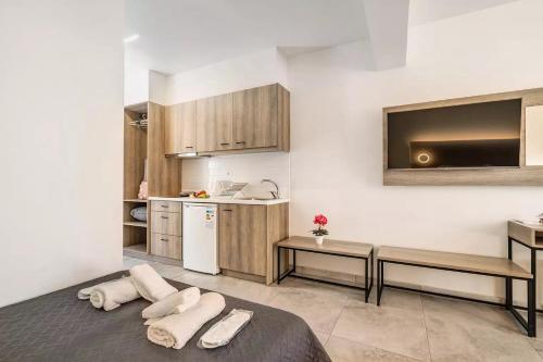 a room with a kitchen and a bed with towels at BLUE STAR APARTHOTEL in Nydri