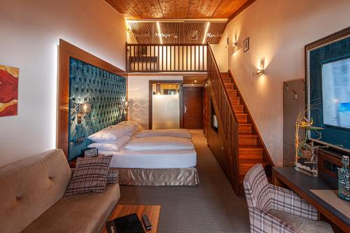 a small room with two beds and a staircase at Boutique Hotel die Mittagspitze Superior in Damuls