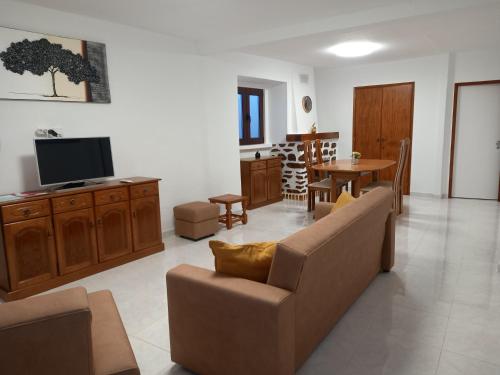 a living room with a couch and a tv and a table at Casa d'Avó in Araújo
