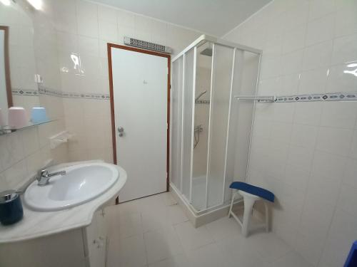 La salle de bains blanche est pourvue d'une douche et d'un lavabo. dans l'établissement Casa d'Avó, à Araújo