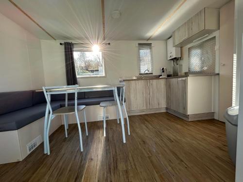 uma cozinha com mesa e cadeiras num quarto em Camping Beaussement LIBERTY climatisé em Chauzon