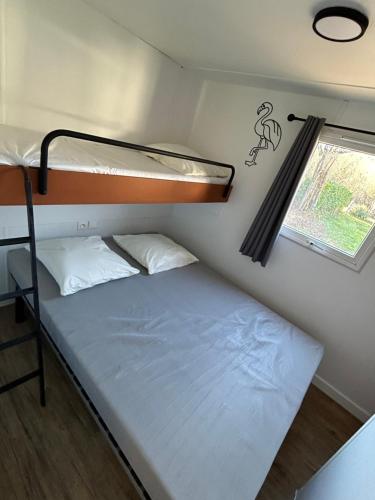 una piccola camera con letto a castello e finestra di Camping Beaussement LIBERTY climatisé a Chauzon