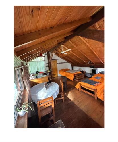 an attic room with a bed and a table and chairs at Casitas del arroyo in Villa General Belgrano