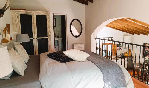 ein Schlafzimmer mit einem Bett in einem Zimmer mit einem Spiegel in der Unterkunft Apartamento Montes by Finca Los Arcos in Comares