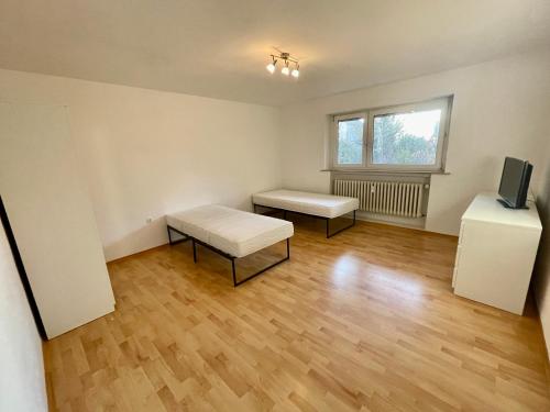 an empty room with two benches and a television at Appartement Luna in Schweinfurt