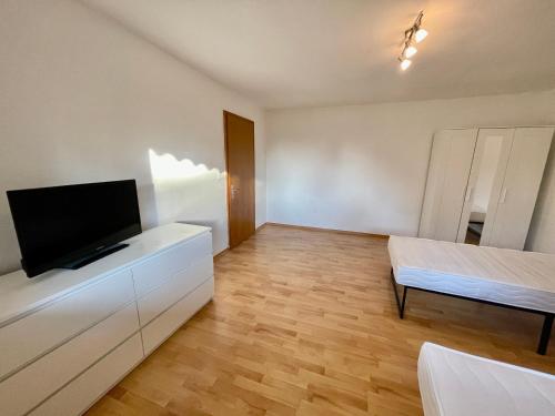a living room with a flat screen tv and a bed at Appartement Luna in Schweinfurt