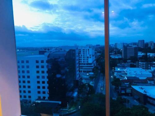 una finestra con vista sullo skyline della città di apartamento avenida las américas a Guatemala