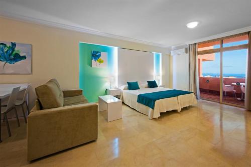 1 dormitorio con cama, sofá y mesa en Kn Aparthotel Panorámica, en Adeje