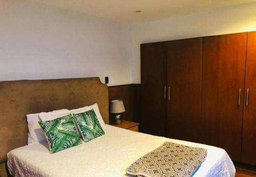 a bedroom with a bed with a wooden cabinet at apartamento avenida las américas in Guatemala
