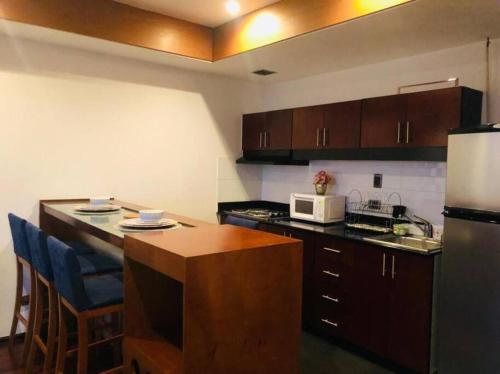 a kitchen with a counter top and a microwave at apartamento avenida las américas in Guatemala