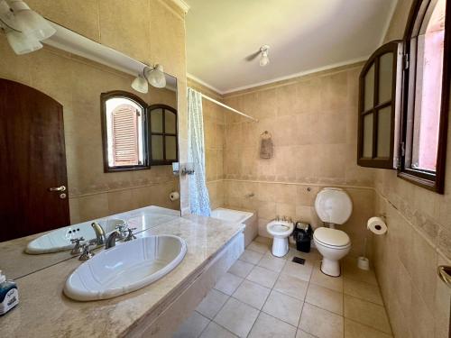 a bathroom with a tub and a toilet and a sink at Casaquinta Haras El Tropicano in Bahía Blanca