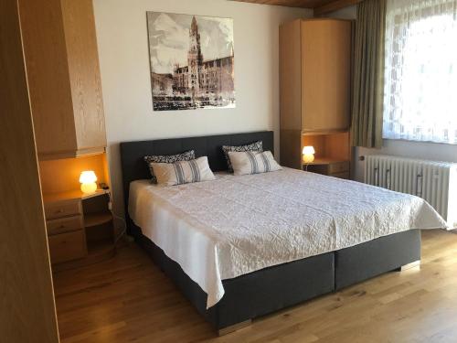 een slaapkamer met een groot bed met 2 nachtkastjes bij Ferienhaus Büttner in Rimsting