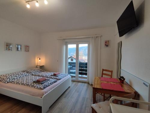 a bedroom with a bed and a table and a window at Landhaus Danita in Bodensdorf