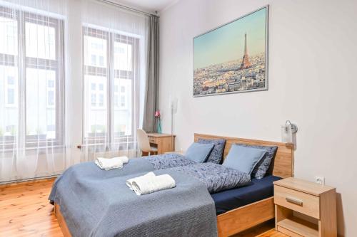 um quarto com uma cama azul com duas toalhas em Przestronne mieszkanie w centrum Gdańska em Gdansk