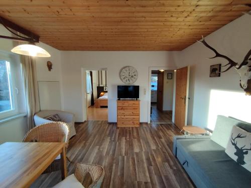 a living room with a table and a clock on the wall at Landhaus Danita in Bodensdorf