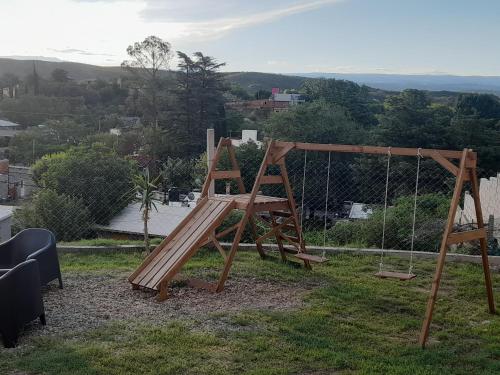 a playground with a swing and a wooden swing at ENCANTO SERRANO in Villa Carlos Paz