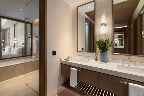a bathroom with two sinks and a large mirror at Casa de Campo Resort & Villas in La Romana