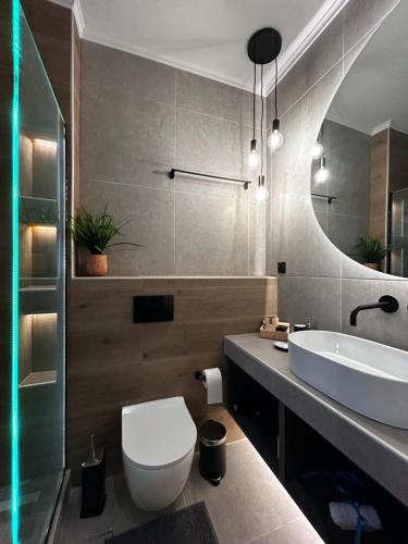 Ocean-Πολυτελές διαμέρισμα στο Αγρίνιο في أغرينيو: حمام به مرحاض أبيض ومغسلة