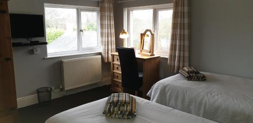 a bedroom with two beds and a dresser and a window at Felpham Guest House - Self Catering in Bognor Regis