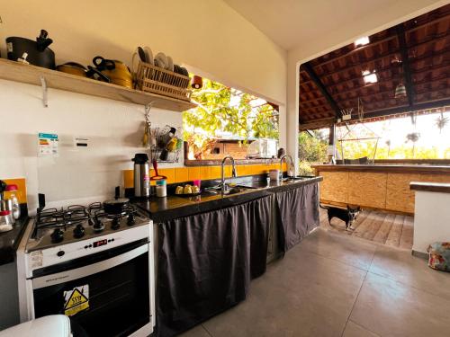a kitchen with a stove and a sink at OXE hostel in Moreré
