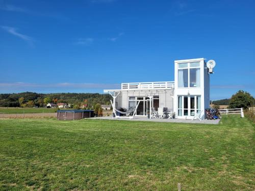 a white house with a lawn in front of it at Domek na Pagórku in Lwówek Śląski