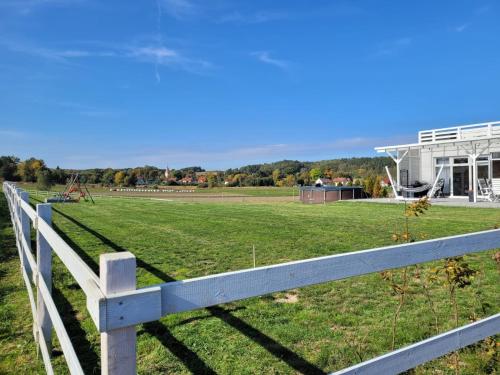 a white fence in front of a field at Domek na Pagórku in Lwówek Śląski