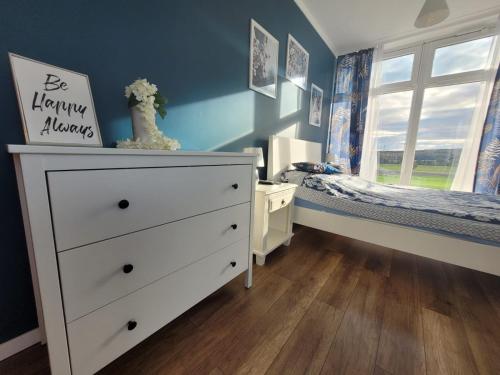 a childs bedroom with a white dresser and a bed at Domek na Pagórku in Lwówek Śląski