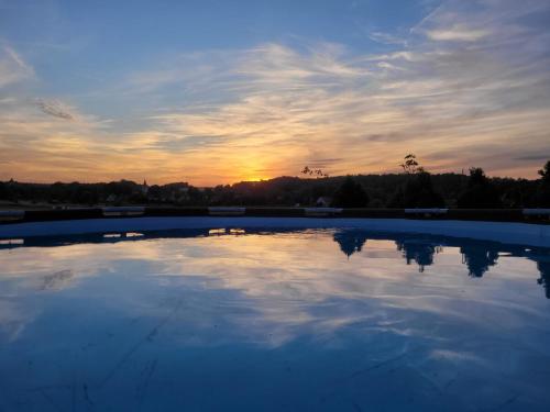 an empty swimming pool with the sunset in the background at Domek na Pagórku in Lwówek Śląski