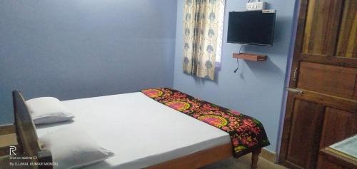 mały pokój z łóżkiem i telewizorem w obiekcie Hotel UK Nest w mieście Sabari